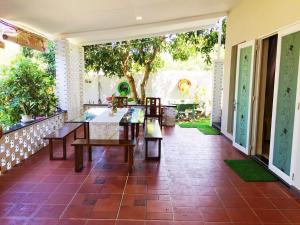 een patio met tafels, stoelen en bomen bij LQ villa -Long Hải in Long Hai
