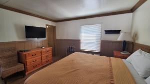 a bedroom with a bed and a tv on the wall at Kernville Inn in Kernville