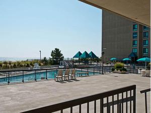 a pool with chairs and umbrellas next to a building at Sea Colony Harbour House in Bethany Beach