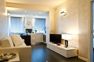 a living room with a white couch and a television at Hotel Ferro di Cavallo in Pavullo nel Frignano