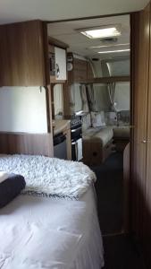 um pequeno quarto com uma cama e uma cozinha em Caravan Glamping Accommodation em Te Awamutu