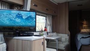 un televisor en un armario en una caravana en Caravan Glamping Accommodation, en Te Awamutu