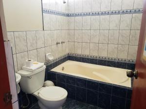 a bathroom with a toilet and a bath tub at Los Naturales in Huaral
