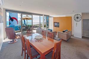 un soggiorno con tavolo in legno e una sala da pranzo. di Sea Quest Apartment a Nelson