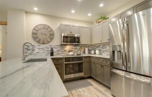 a kitchen with stainless steel appliances and a clock on the wall at Cs302 Copper Springs Condo in Copper Mountain