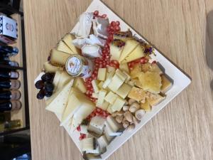 a plate filled with different types of cheese and grapes at B&B A Pochi Passi in Polignano a Mare