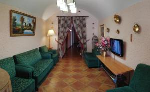 ein Wohnzimmer mit grünen Sofas und einem TV in der Unterkunft Apartamentos Horno y Casa De Dulce in Purullena