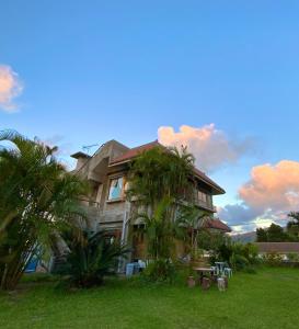 石垣島的住宿－イリワ -stay&coffee iriwa-，前面有棕榈树的房子