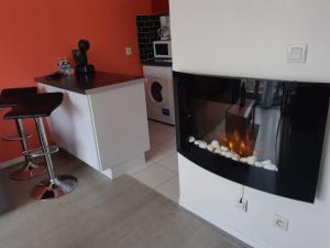 a living room with a fireplace in a kitchen at DISNEYLAND PARIS/VAL 2 APART' in Montévrain