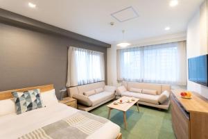 Habitación de hotel con cama, sofá y TV en PLAYSIS East Tokyo, en Tokio