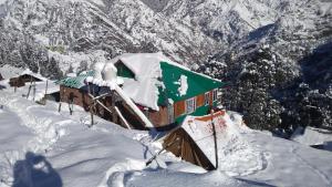 a house covered in snow on top of a mountain at Himalayan High Trekkers Lodge - Sankri in Sankri