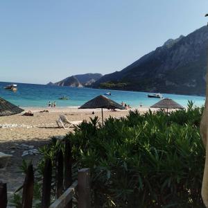 a beach with umbrellas and people in the water at Leontopolis Apart Otel in Cıralı