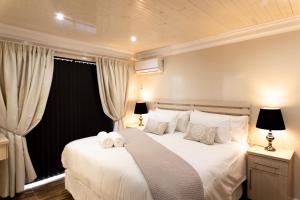 เตียงในห้องที่ Grand House Lodge And SPA Jeffreys Bay