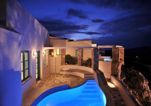 a villa with a swimming pool at night at Kifines Suites in Chora Folegandros