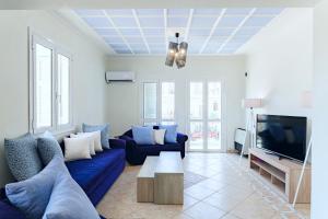Una sala de estar con un sofá azul y un televisor. en KEFALONIA'S HIDDEN GEMS!, en Argostoli