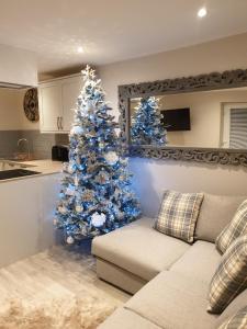 a blue christmas tree in a living room with a couch at Luxury five star cottage one 