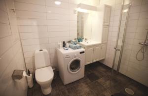 a bathroom with a toilet a sink and a washing machine at Modern apartment in Svolvær +8 photos