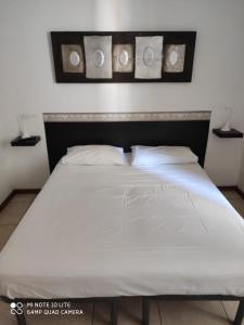 a bed with white sheets and pillows in a room at Casa di Alfredo Affittacamere in Siena
