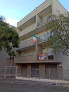 ein Apartmenthaus mit einer Flagge auf dem Balkon in der Unterkunft CasaSylvia in Cassano delle Murge