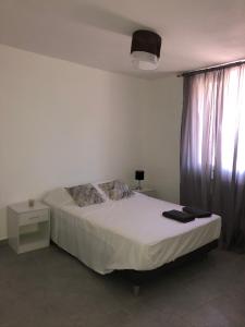 ein Schlafzimmer mit einem weißen Bett und einem Fenster in der Unterkunft Gîte Luna in Sablet