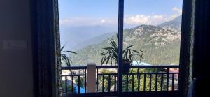 a window with a view of a mountain at Seven Hills Homestay in Kalimpong