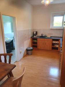 a kitchen with a table and a sink and a counter at Apartmenthaus Am Schlosspark in Schkopau