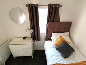 - une petite chambre avec un lit et un miroir dans l'établissement Milton House - Entire 3Bed House FREE WIFI & 4 FREE PARKING Spaces Serviced Accommodation Newcastle UK, à Newcastle upon Tyne