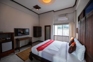 um quarto com uma cama e uma televisão e uma cama sidx sidx em Chirin Home ฌิรินทร์โฮม em Chiang Mai