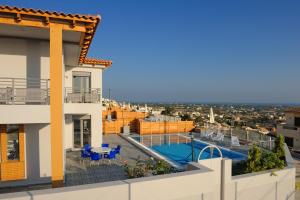 een uitzicht vanaf het balkon van een huis met een zwembad bij Danae Villas in Chersonissos