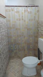 uma casa de banho com um WC e uma cortina de chuveiro em Rumanija's Airport Rooms em Zanderij