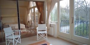 a room with white chairs and a sliding glass door at Ruime comfortabele villa Ouddorp in Ouddorp