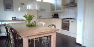 a kitchen with a wooden table and some chairs at Ruime comfortabele villa Ouddorp in Ouddorp