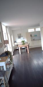 a living room with a wooden table and a kitchen at Ruime comfortabele villa Ouddorp in Ouddorp