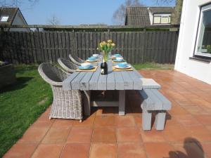 a picnic table with chairs on a patio at Ruime comfortabele villa Ouddorp in Ouddorp +6 photos