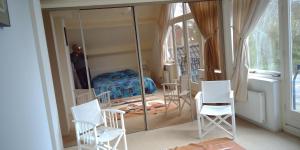 a room with white chairs and a mirror at Ruime comfortabele villa Ouddorp in Ouddorp