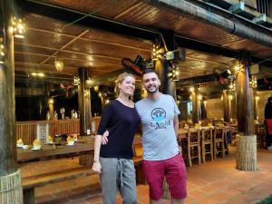 a man and a woman standing in front of a restaurant at PU LUONG BOUTIQUE GARDEN in Pu Luong