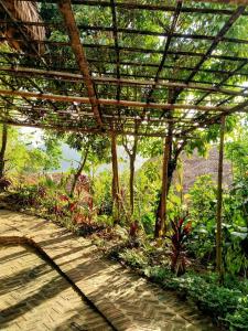 una pérgola en un jardín con árboles y plantas en PU LUONG BOUTIQUE GARDEN en Pu Luong