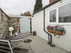 un patio avec une table et des chaises ainsi qu'un garage dans l'établissement Potter Hill Cottage, à Pickering