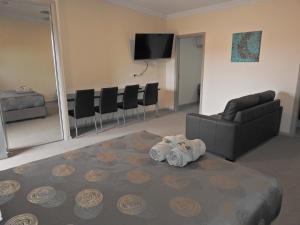 a living room with a couch, chair and a television at Broken Hill Outback Resort in Broken Hill