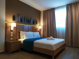 ein Hotelzimmer mit einem Bett und einem Fenster in der Unterkunft La Place Suites - La Place De La Gare in Thessaloniki
