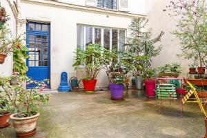 Un mucchio di piante in vaso davanti a un edificio. di Superb Mini Loft close Montmartre 2 people a Parigi