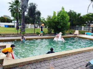 people playing in a pool of water at Berrigan Motel in Berrigan
