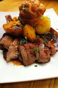 a plate of meat and potatoes on a table at The Thames Hotel in Maidenhead