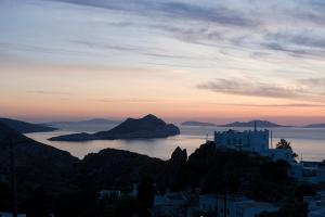 uitzicht op de stad en de oceaan bij zonsondergang bij Pagali Hotel in Órmos Aiyialís
