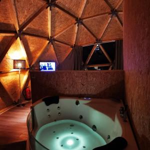 a bath room with a large tub and a large mirror at Natura Glamping in Alcongosta