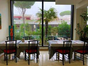 a dining room with tables and chairs and a large window at Hotel Logonovo in Lido degli Estensi