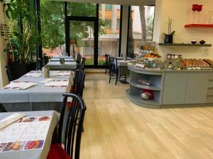 a restaurant with tables and a counter with food at Hotel Logonovo in Lido degli Estensi