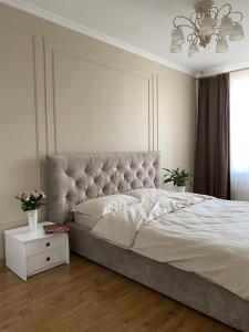 ein weißes Schlafzimmer mit einem großen Bett und einem Fenster in der Unterkunft Luxury apartment near metro station Osokorky in Kiew