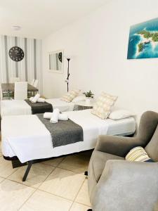 um quarto de hotel com duas camas e um sofá em Primera línea de mar ! Fantástico apartamento em Adeje