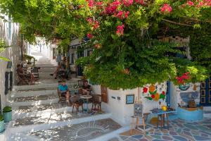 a group of people sitting at tables on a street at Pagali Hotel in Órmos Aiyialís